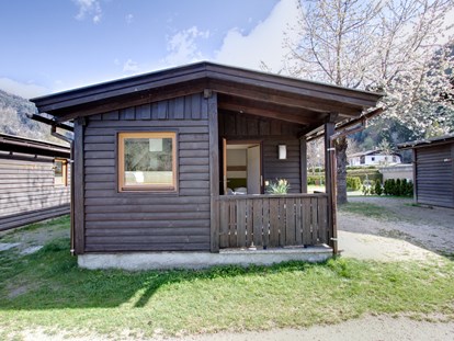 Luxuscamping - TV - Chalet Außenansicht - Frühling - Camping Brunner am See Chalets auf Camping Brunner am See
