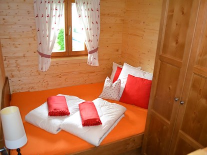 Luxuscamping - Österreich - Ferienhütte "Schober": Schlafzimmer mit Doppelbett und einem Stockbett - CAMP MondSeeLand Ferienhütten am CAMP MondSeeLand