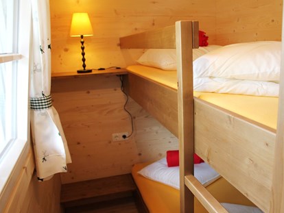 Luxuscamping - Gartenmöbel - Ferienhütte "Schafberg": Kinderzimmer mit einem Stockbett - CAMP MondSeeLand Ferienhütten am CAMP MondSeeLand