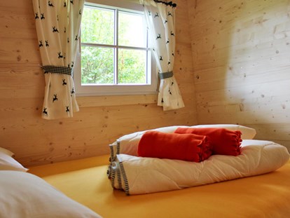 Luxuscamping - Kaffeemaschine - Ferienhütte "Schafberg: Schlafzimmer mit Doppelbett - CAMP MondSeeLand Ferienhütten am CAMP MondSeeLand