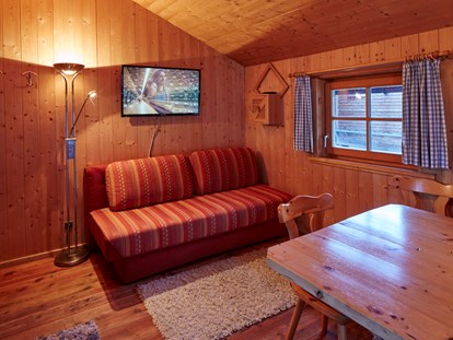 Luxuscamping - Tirol - ausziehbare Couch, gemütlicher Ess- Sitzbereich - Camping Dreiländereck in Tirol Kleine Blockhütte Camping Dreiländereck Tirol