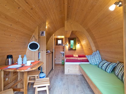 Luxuscamping - Art der Unterkunft: Hütte/POD - Nordrhein-Westfalen - Sitzecke, Doppelbett und Couch im Pod © Campingpark Kerstgenshof - Campingpark Kerstgenshof Pods auf dem Campingpark Kerstgenshof
