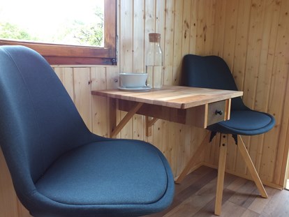 Luxuscamping - Kochmöglichkeit - Hessen Nord - Sitz- und Essbereich im Blaumeischen - Ecolodge Hinterland Bauwagen Lodge