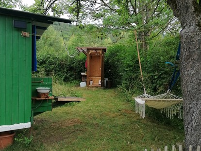 Luxuscamping - Art der Unterkunft: Zirkuswagen/Schäferwagen - Biedenkopf - Außenbereich mit Hängematte - Ecolodge Hinterland Bauwagen Lodge