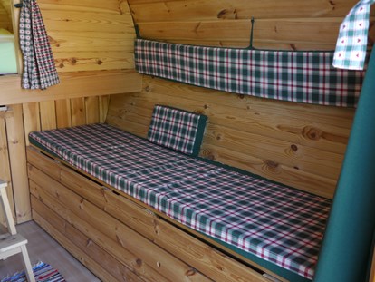 Luxuscamping - Heizung - Bayern - Die Bank lässt sich verbreitern, so dass ein Einzelbett entsteht auf dem auch ein Erwachsener liegen kann (2,10 x 0,70 cm). - Lech Camping Schlaf-Fass bei Lech Camping