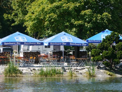 Luxuscamping - Hunde erlaubt - Region Augsburg - Hier ein Blick vom See auf die Seeterrasse unseres Restaurants. - Lech Camping Schlaf-Fass bei Lech Camping
