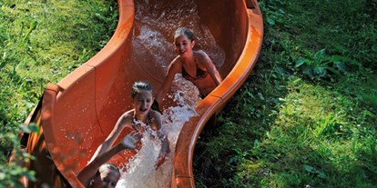 Luxuscamping - Sonnenliegen - Tirol - Wasserrutsche am eigenen Badesee - Nature Resort Natterer See Safari-Lodge-Zelt "Rhino" am Nature Resort Natterer See