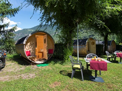 Luxuscamping - Heizung - Trentino - Tisch mit 2 Stühlen im Aussenbereich, Auto/Motorradparkplatz direkt am Schlaffass. - Camping Steiner Schlaffass auf Camping Steiner