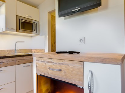 Luxuscamping - Kochmöglichkeit - Chalet Wohnraum mit artifical fire place - Camping Brunner am See Chalets auf Camping Brunner am See
