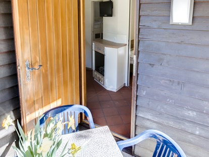 Luxuscamping - Kühlschrank - Chalet Eingangsbereich mit kleiner Terrasse - Camping Brunner am See Chalets auf Camping Brunner am See