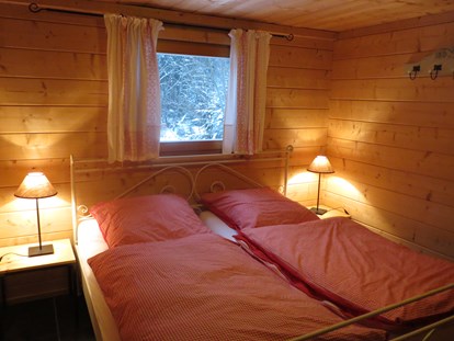 Luxuscamping - Kochmöglichkeit - Deutschland - Landhaus - Schlafzimmer mit Doppelbett - Camping Langenwald Blockhäuser auf Camping Langenwald