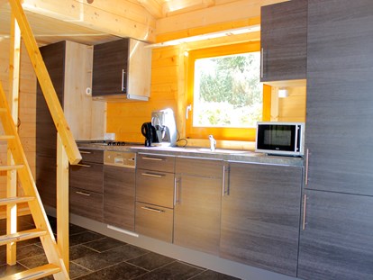 Luxuscamping - Sonnenliegen - Deutschland - Küchenzeile mit Kochgelegenheit, Spülmaschine, Mikrowelle und Kaffeemaschine - Camping Langenwald Blockhäuser auf Camping Langenwald