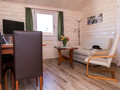 Luxuscamping - Massagen - Wohn- und Essbereich im Ferienhäuschen - Ostseecamping Ferienpark Zierow