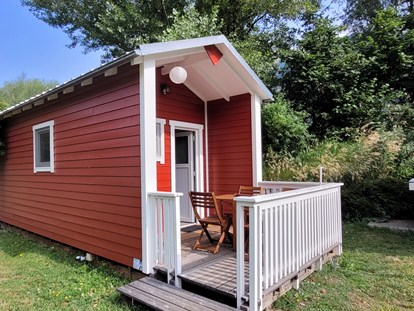 Luxuscamping - Art der Unterkunft: Tiny House - Aussenansicht des Woody mit eigener Holzterasse und Beleuchtung - Camping Santa Monica Woody