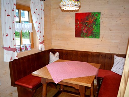 Luxuscamping - Art der Unterkunft: Bungalow - Ferienhütte "Schober": gemütliche Sitzecke - CAMP MondSeeLand Ferienhütten am CAMP MondSeeLand