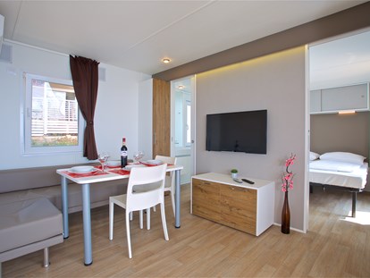 Luxuscamping - getrennte Schlafbereiche - Wohnzimmer mit Esstisch und Stühlen
 - Camping Cikat Mobilheime Typ C auf Camping Cikat