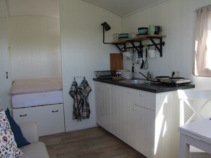 Luxuscamping - Kühlschrank - Niedersachsen - Die  kleine Küchenzeile - Nordseestrand in Dornumersiel Pipowagen auf dem Campingplatz am Nordseestrand in Dornumersiel