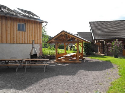 Luxuscamping - Parkplatz bei Unterkunft - Schwarzwald - Grillstelle hinter den Naturstammhäusern - Schwarzwälder Hof Naturstammhaus auf Schwarzwälder Hof