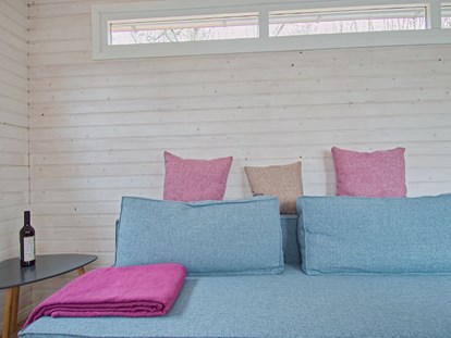 Luxuscamping - Preisniveau: gehoben - Sitzecke mit Couchtisch - Naturcampingpark Rehberge Tiny House am See - Naturcampingpark Rehberge